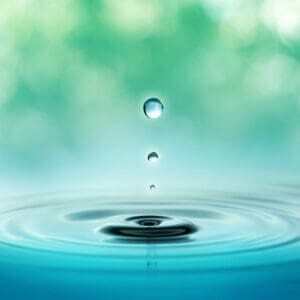 Close,Up,Of,Three,Droplets,In,A,Blurred,Green,Background close up of three droplets in a blurred green background